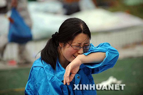 5月14日，張關(guān)蓉在丈夫譚千秋的遺體旁痛哭。 受汶川地震影響，四川省德陽市東汽中學教學樓坍塌。在地震發(fā)生的一瞬間，該校教導主任譚千秋雙臂張開趴在課桌上，身下死死地護著4個學生，4個學生都獲救了，譚老師卻不幸遇難。 新華社記者王建華攝 