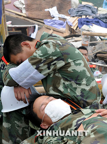 5月17日，救援人員在四川省什邡市救災現(xiàn)場抓緊時間小憩。 汶川地震發(fā)生后，救援人員奔赴各個災區(qū)，爭分奪秒、夜以繼日地在搜救現(xiàn)場奮戰(zhàn)。為了盡量多地救出掩埋在廢墟下的生還者，他們與時間賽跑，利用有限的空閑稍事休息，補充體力。