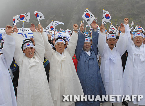7月14日，大批韓國人在獨(dú)島（日本稱“竹島”）手舉國旗抗議。韓國外交通商部發(fā)言人文太暎當(dāng)日發(fā)表聲明，強(qiáng)烈抗議日本在當(dāng)天公布的中學(xué)教科書指導(dǎo)手冊中將獨(dú)島（日本稱“竹島”）表述為日本領(lǐng)土，并要求日本立即對有關(guān)內(nèi)容進(jìn)行修正。韓國外交通商部將采取召回韓國駐日本大使和召見日本駐韓國大使這兩項(xiàng)外交措施，就此問題向日本政府表示強(qiáng)烈抗議。 新華社/法新 