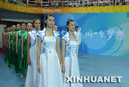 7月20日，志愿者們準(zhǔn)備進(jìn)行頒獎(jiǎng)儀式服裝展示。當(dāng)日，北京奧運(yùn)會(huì)、殘奧會(huì)體育展示與頒獎(jiǎng)儀式工作匯報(bào)暨誓師動(dòng)員大會(huì)在北京理工大學(xué)體育館舉行，集中匯報(bào)展示了北京奧運(yùn)會(huì)、殘奧會(huì)頒獎(jiǎng)儀式服裝及頒獎(jiǎng)儀式標(biāo)準(zhǔn)流程、競(jìng)技拉拉操表演、民族民間舞蹈表演和吉祥物表演等項(xiàng)目。 新華社記者羅曉光攝 