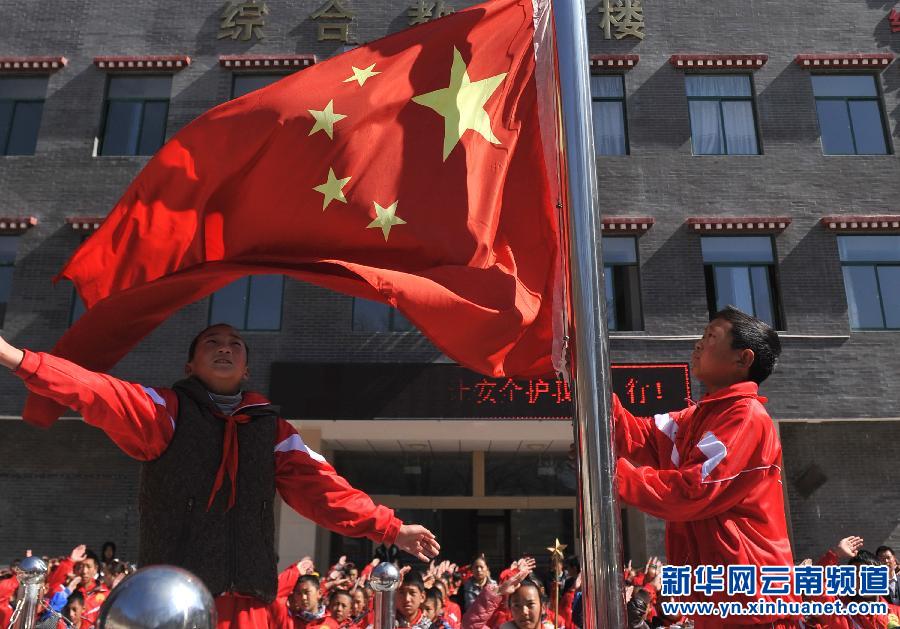 3月17日，云南省迪慶藏族自治州德欽縣第一小學(xué)學(xué)生在教學(xué)樓前參加升旗儀式。新華社 藺以光 攝