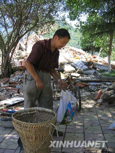 7月5日，北川縣城的一位居民在縣城內(nèi)尋找自己的物品。當(dāng)日，記者經(jīng)特許進(jìn)入地震重災(zāi)區(qū)北川縣城采訪，用相機(jī)記錄下北川縣城的現(xiàn)狀。 